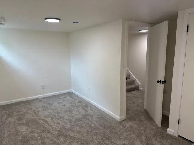 Neutral-toned walls complement plush grey carpeting throughout this space