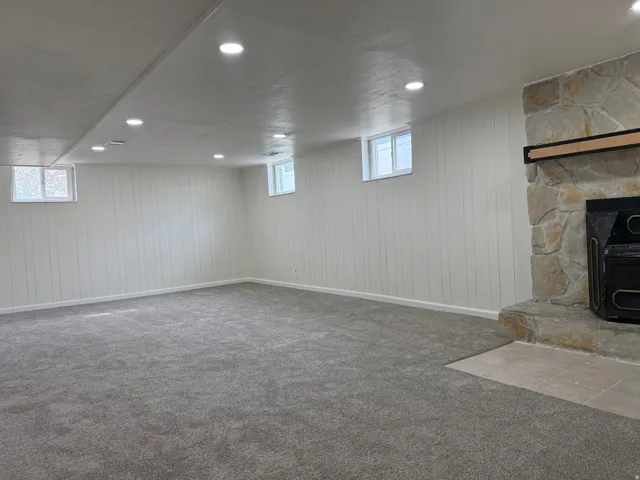 Spacious room featuring new gray carpeting and white vertical paneling
