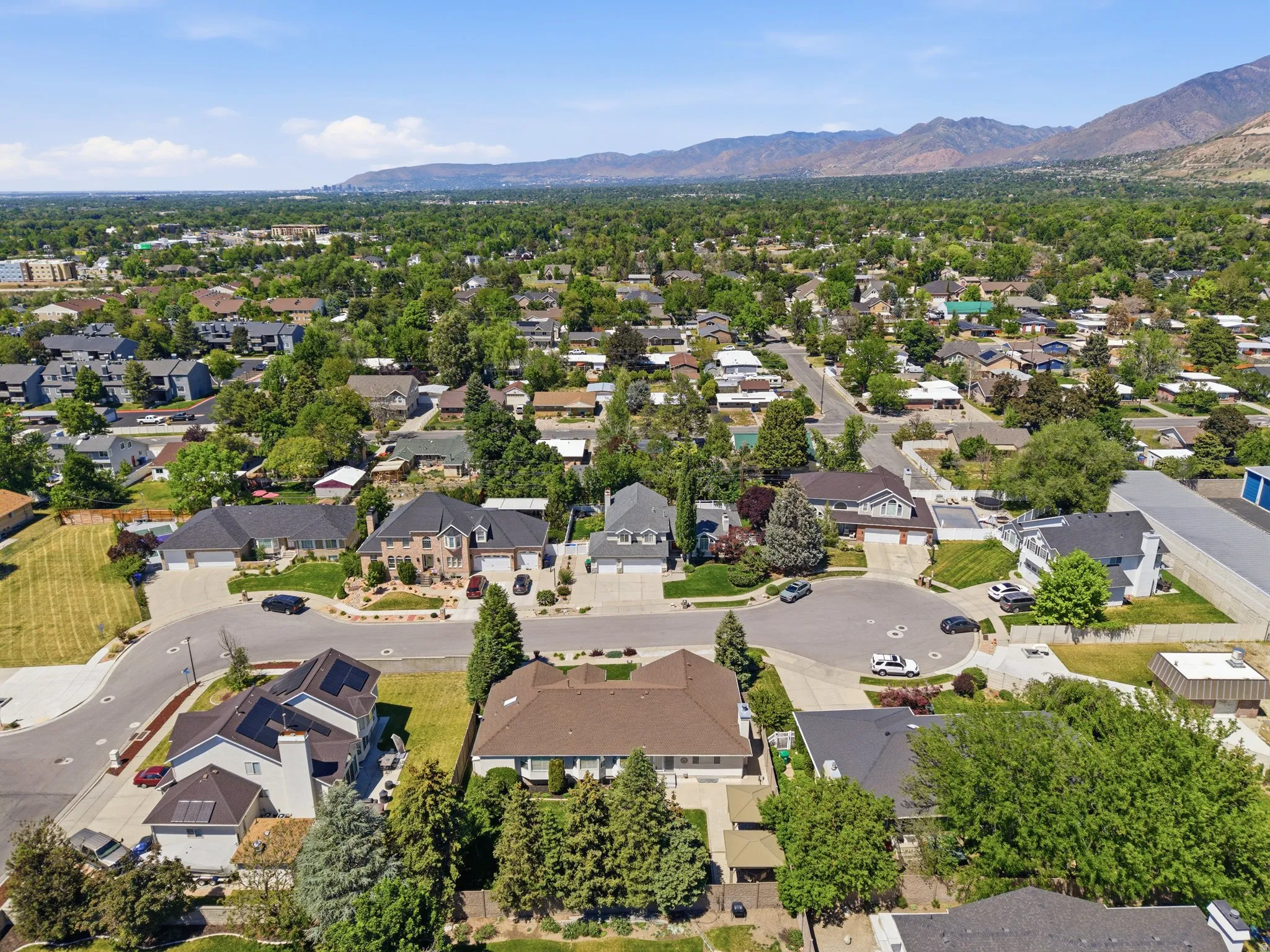 Residential neighborhood featuring a diverse collection of homes, mature trees, and mountainous backdrop