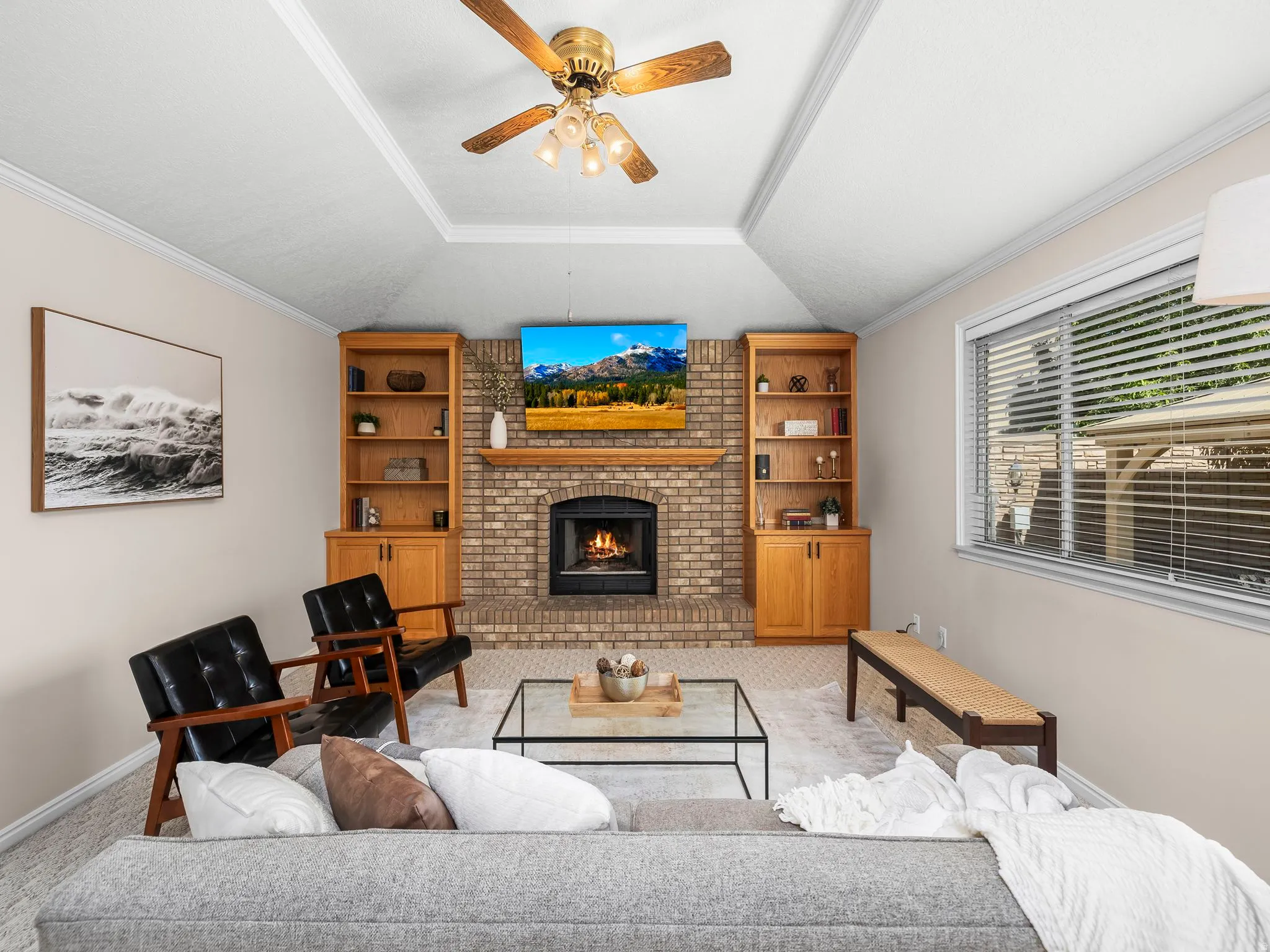 Living area featuring a brick fireplace, wood mantel, and built-in shelving