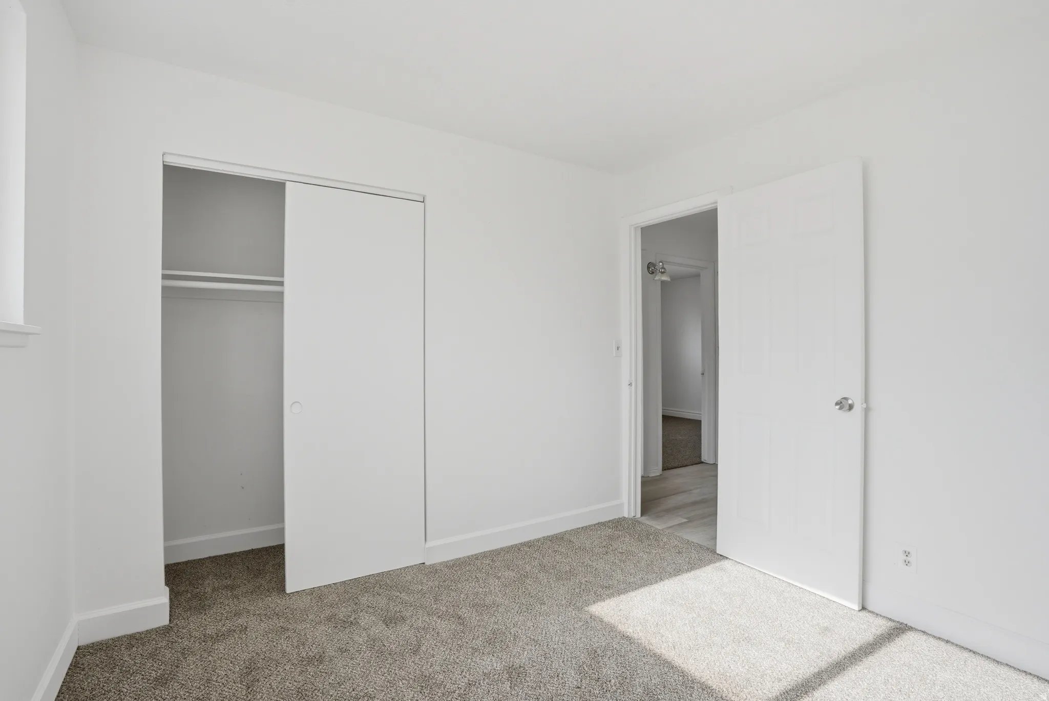 Room with plush carpet flooring, white walls, and a window