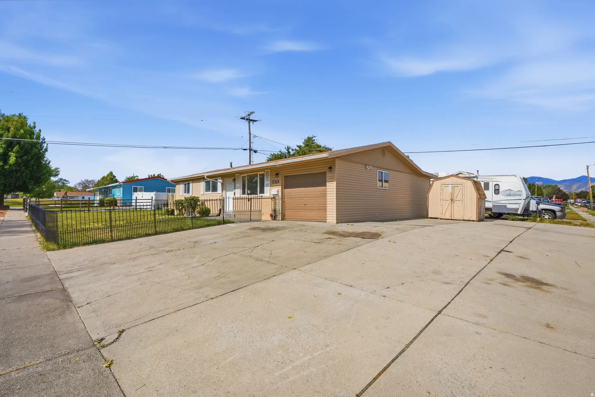 Ranch-style exterior with beige siding, an attached single-car garage, and a concrete driveway