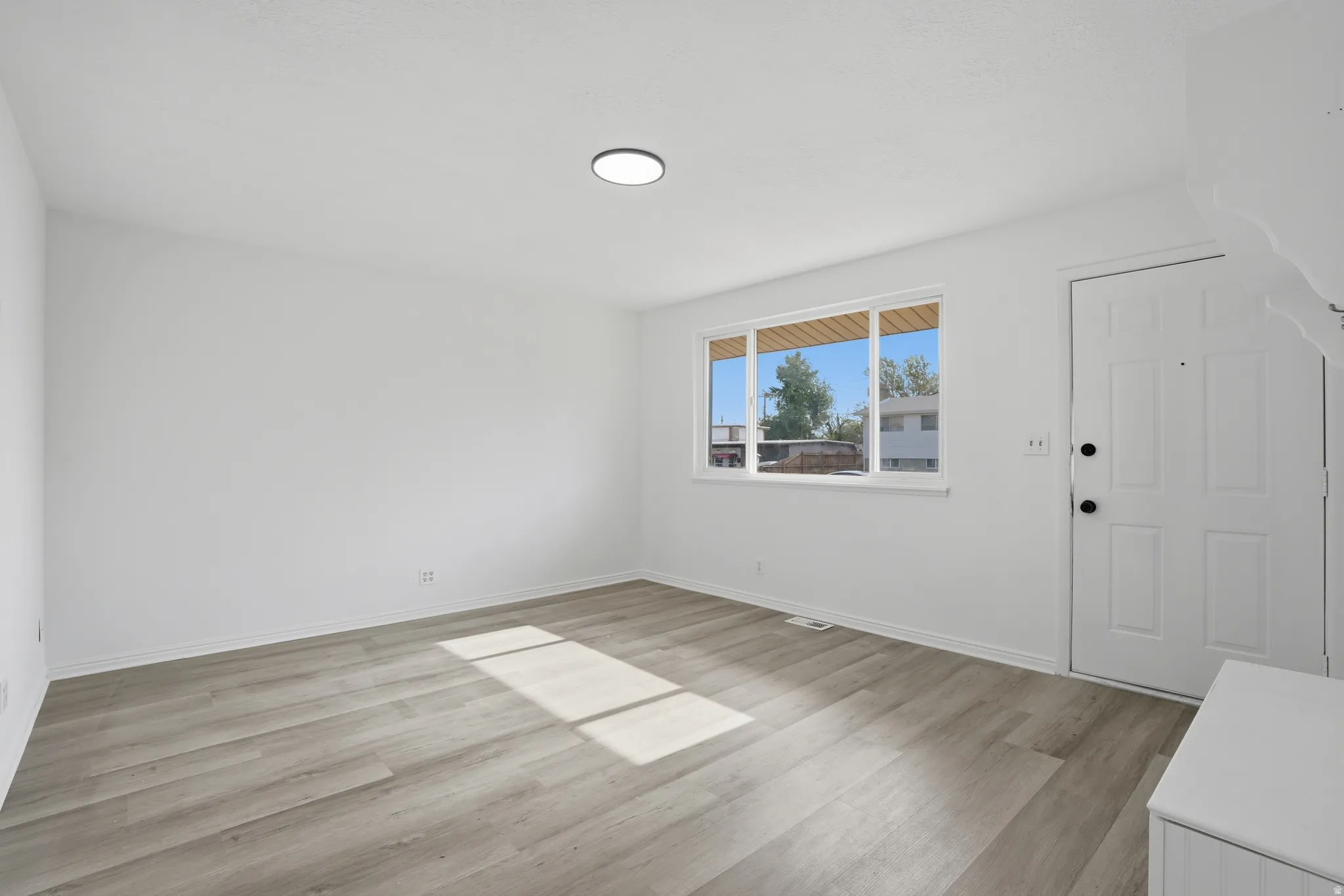 Bright interior space featuring light-toned wood-finish flooring