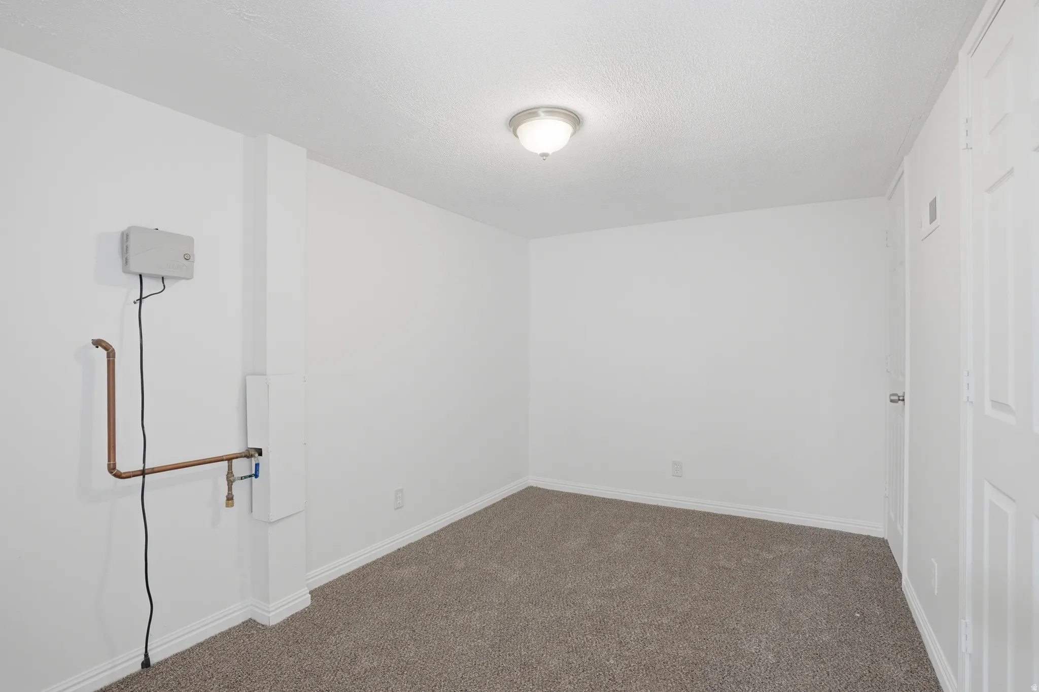 Room featuring a neutral carpet, white baseboards, and a semi-flush mount ceiling light
