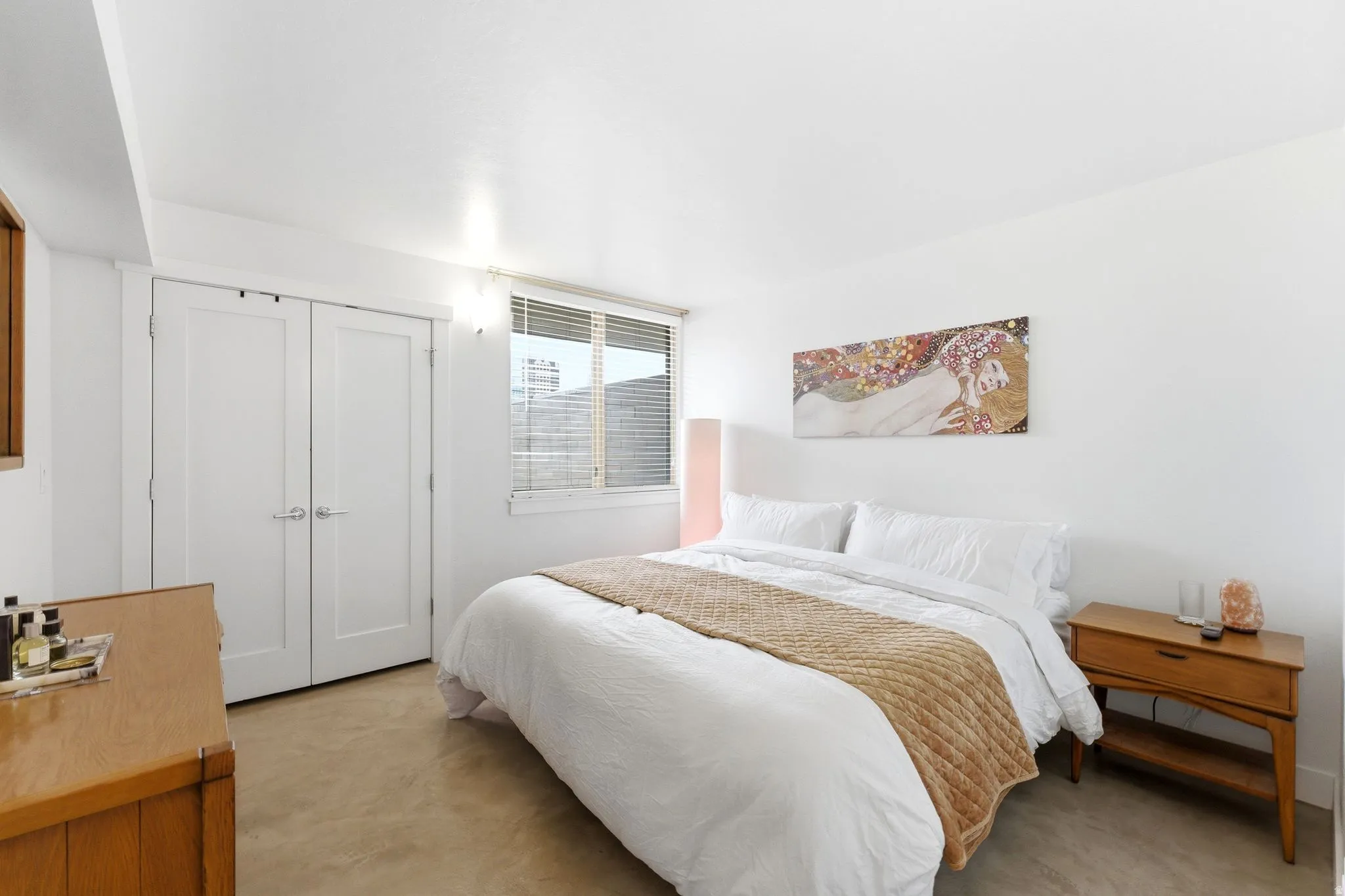 Bedroom featuring light-colored flooring, white walls, and a window with blinds