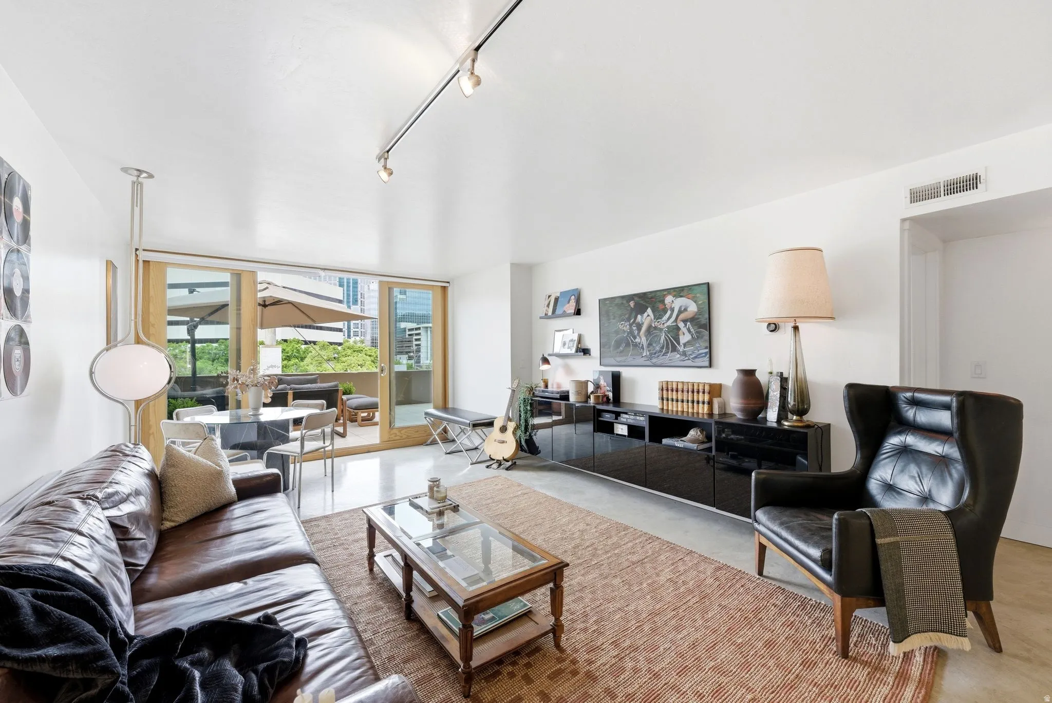 Bright living space with wood-finish flooring and track lighting