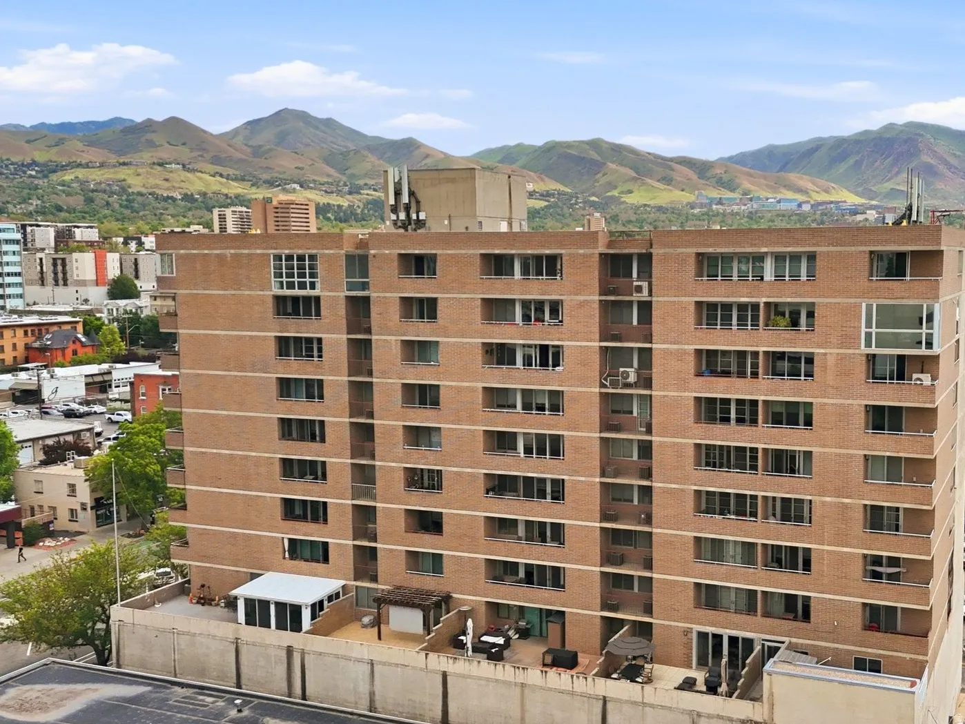 Multi-story brick building with multiple balconies and a flat roof