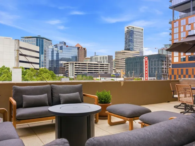 Rooftop terrace featuring concrete flooring, a low perimeter wall, and a cityscape backdrop