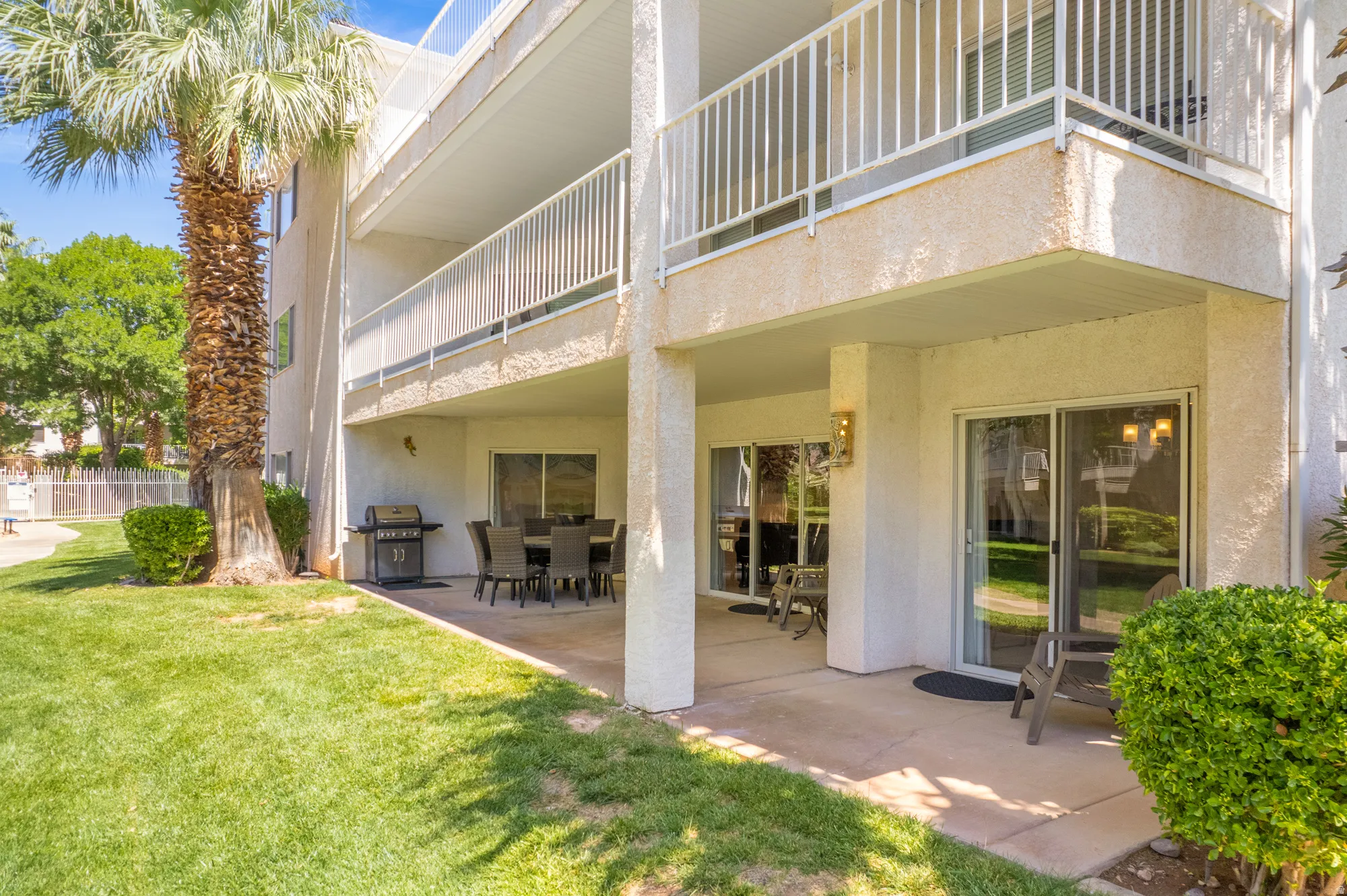 Ground-level unit with a private patio offering direct access to a manicured lawn
