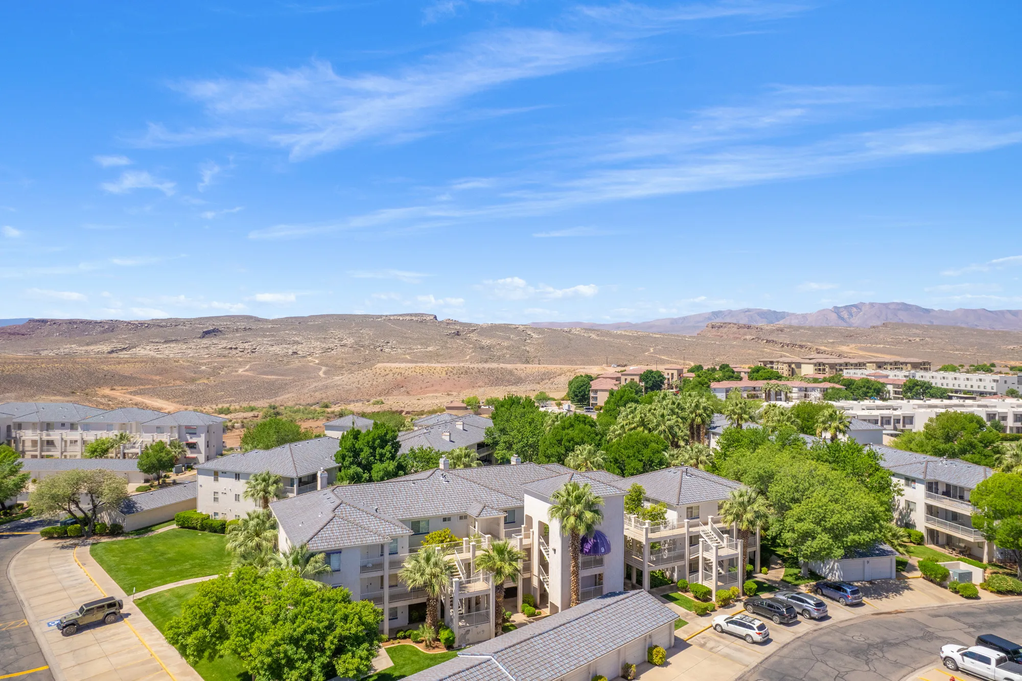 Multi-level residential buildings featuring light-toned exteriors and dark tile roofs