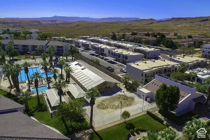 Expansive swimming pool area with multiple rectangular pools and surrounding lounge seating, framed by numerous palm trees