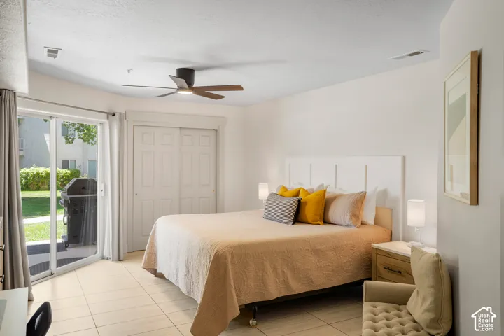 Spacious room featuring light-toned tile flooring and a ceiling fan with wood-finish blades