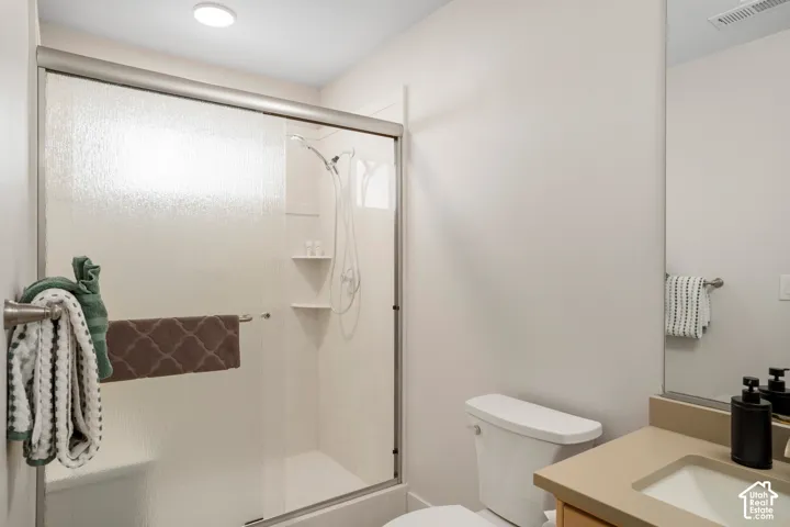 Bathroom featuring a glass-enclosed shower with integrated shelving, a built-in shower bench, and a mounted showerhead
