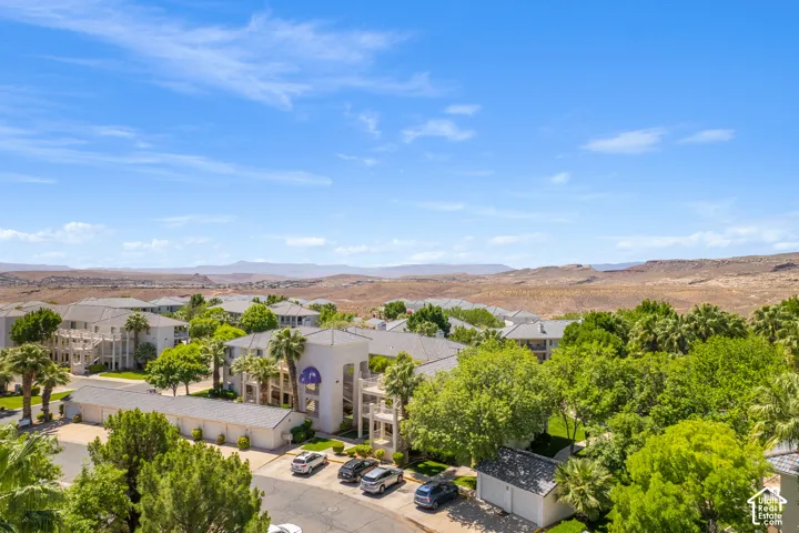 Lush green landscaping surrounding multi-story residential buildings with a desert mountain backdrop