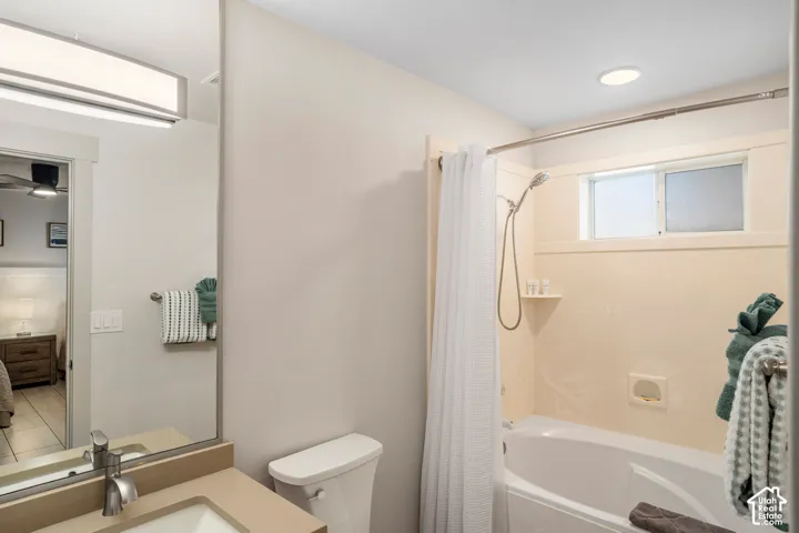 Bathroom featuring a single vanity with a solid surface countertop, an undermount sink, and a brushed nickel faucet