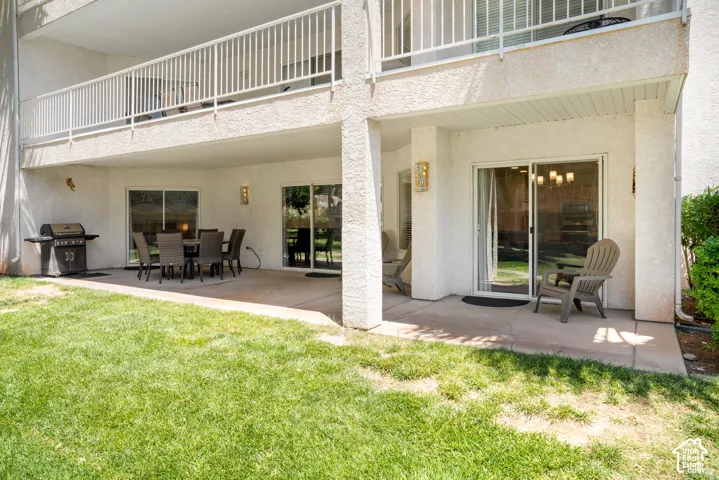 Ground-level patio with a spacious concrete surface, covered overhang, and exterior wall sconces