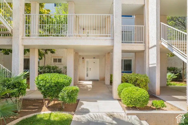 Cream-colored stucco exterior with white railings and exterior staircases