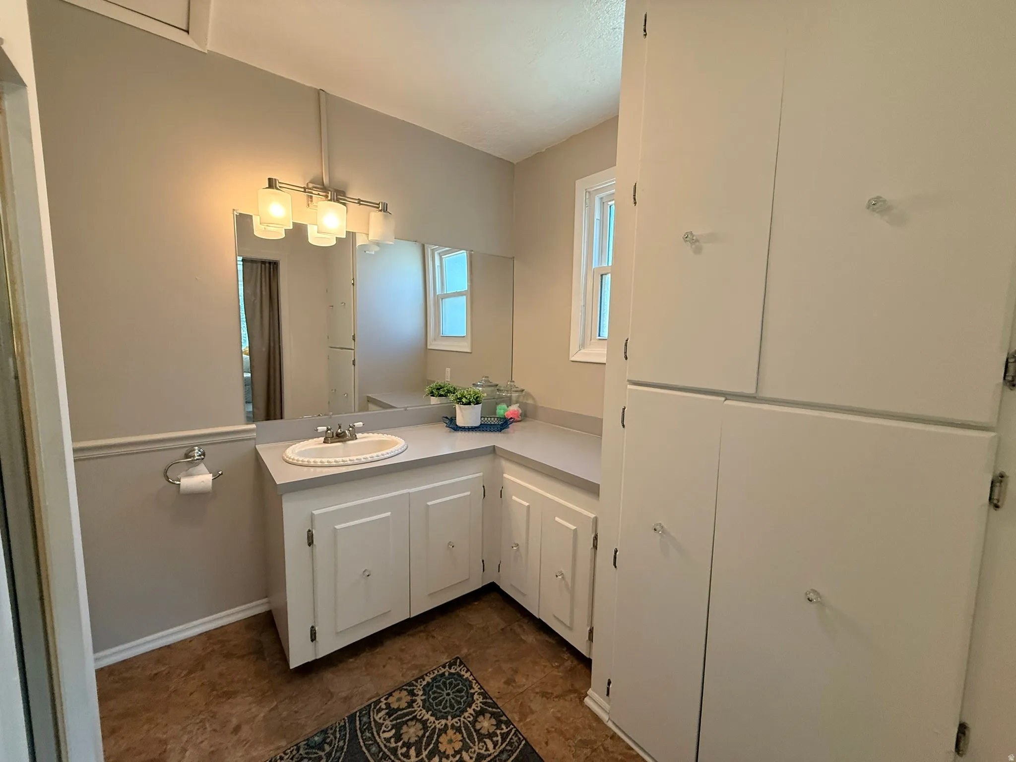 Vanity with an integrated sink, extended countertop, and built-in white cabinetry