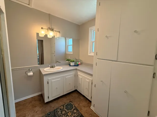 Vanity with an integrated sink, extended countertop, and built-in white cabinetry