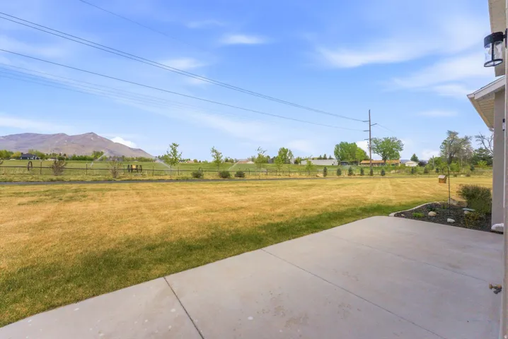 Expansive grassy yard with mountain backdrop and sprinkler system