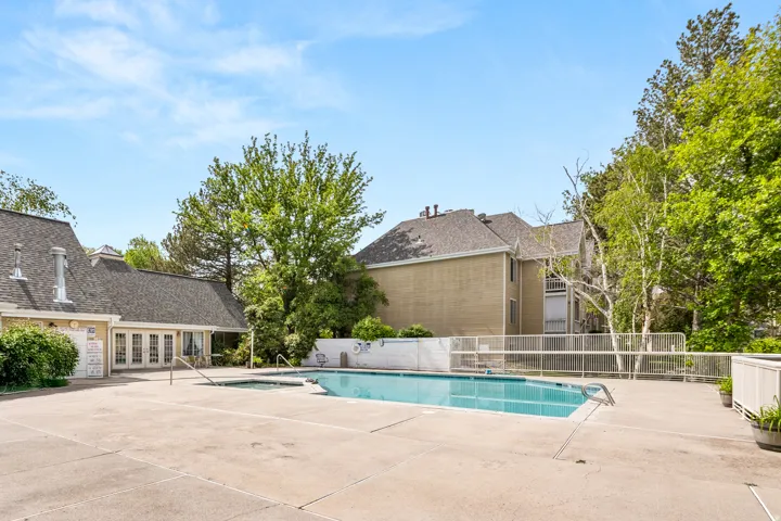 Outdoor swimming pool with integrated spa and surrounding concrete decking