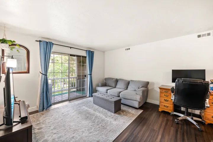 Living area featuring dark wood-finish flooring and white walls