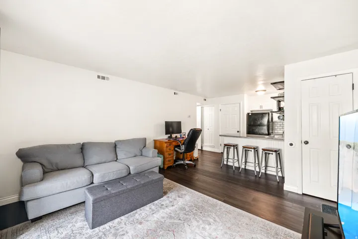 Open-concept living space featuring wood-finish flooring, white walls, and recessed lighting