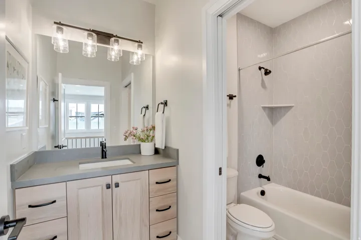 Bathroom featuring a single vanity with wood-finish cabinetry, a light gray countertop, and a rectangular undermount sink