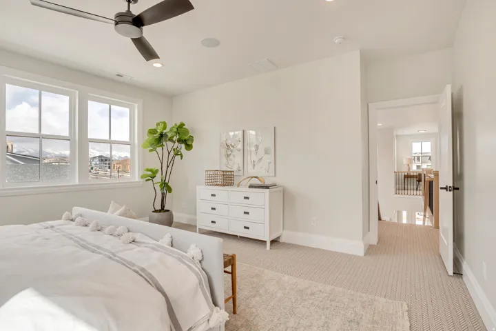 Bright room featuring two large windows, a ceiling fan with integrated lighting, recessed lighting, and soft carpet flooring
