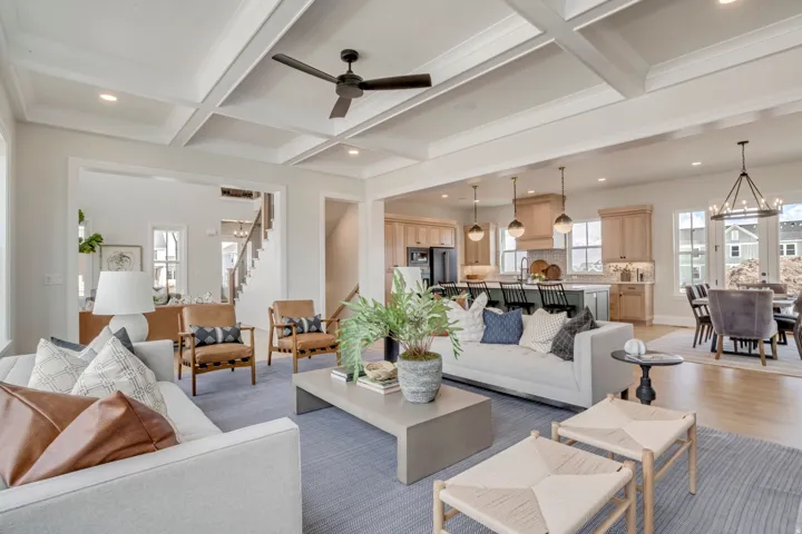 Expansive open-concept interior featuring coffered ceilings, recessed lighting, and a contemporary ceiling fan