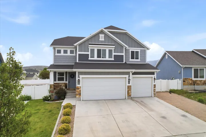 Contemporary two-story residence featuring a gray and blue facade with multiple window styles