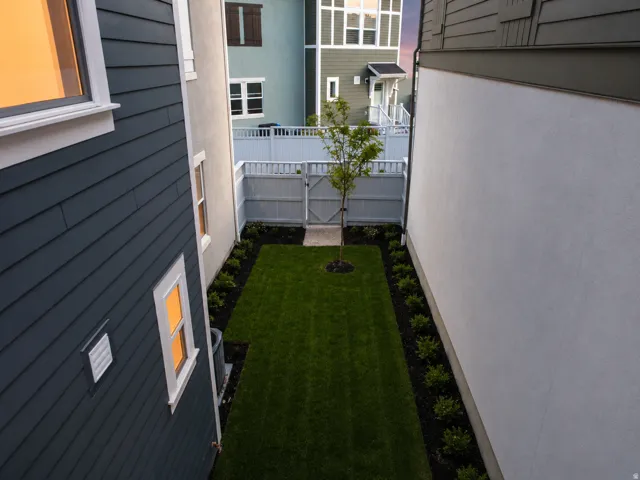 Private backyard space featuring a manicured lawn and perimeter landscaping