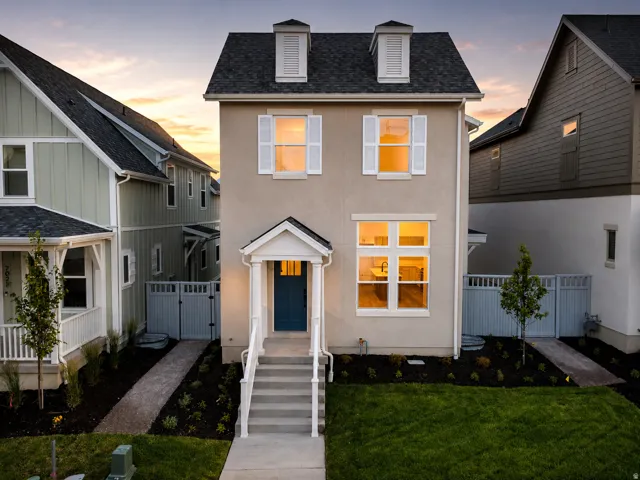 Stucco exterior with a prominent front entrance featuring a blue door, covered porch, and white columns