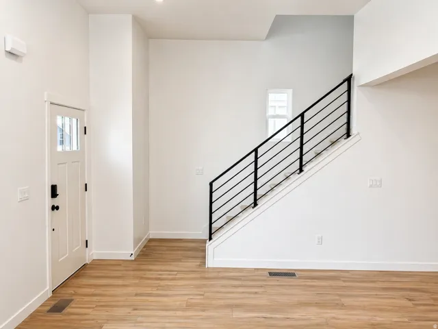 Staircase featuring modern black metal railings and white risers