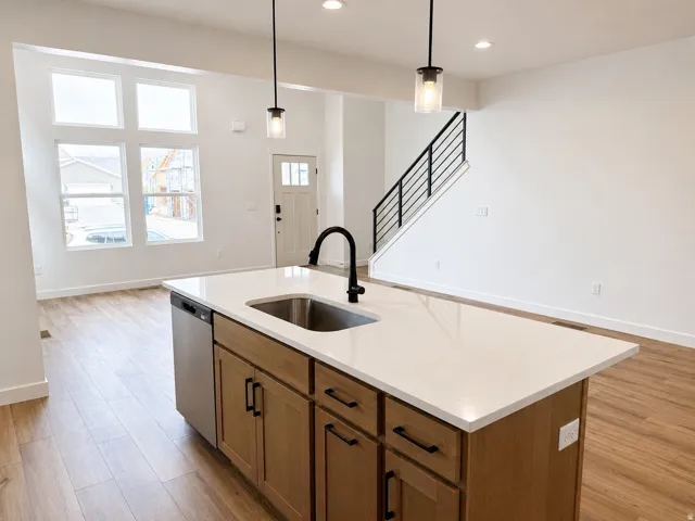 Kitchen island featuring a stainless steel sink, black faucet, and white countertop
