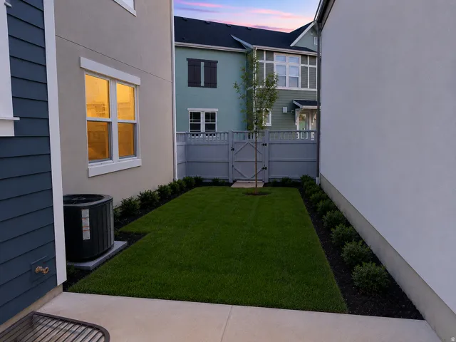 Private outdoor space featuring a manicured lawn, perimeter landscaping, and a privacy fence with gate
