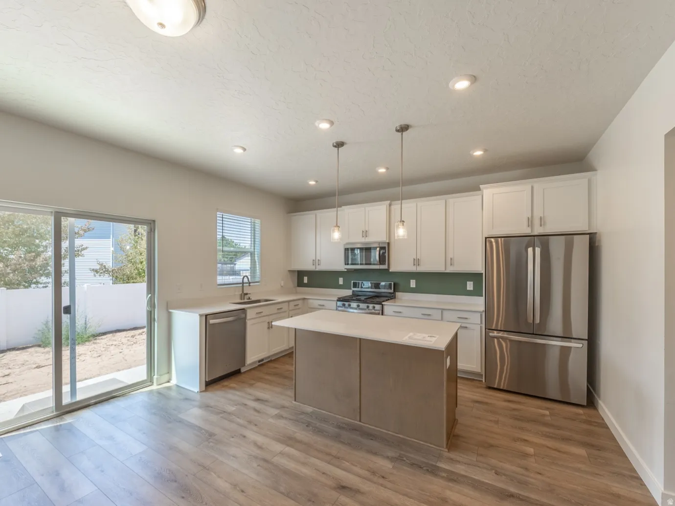 Spacious kitchen with white cabinets and beautiful LVP flooring.