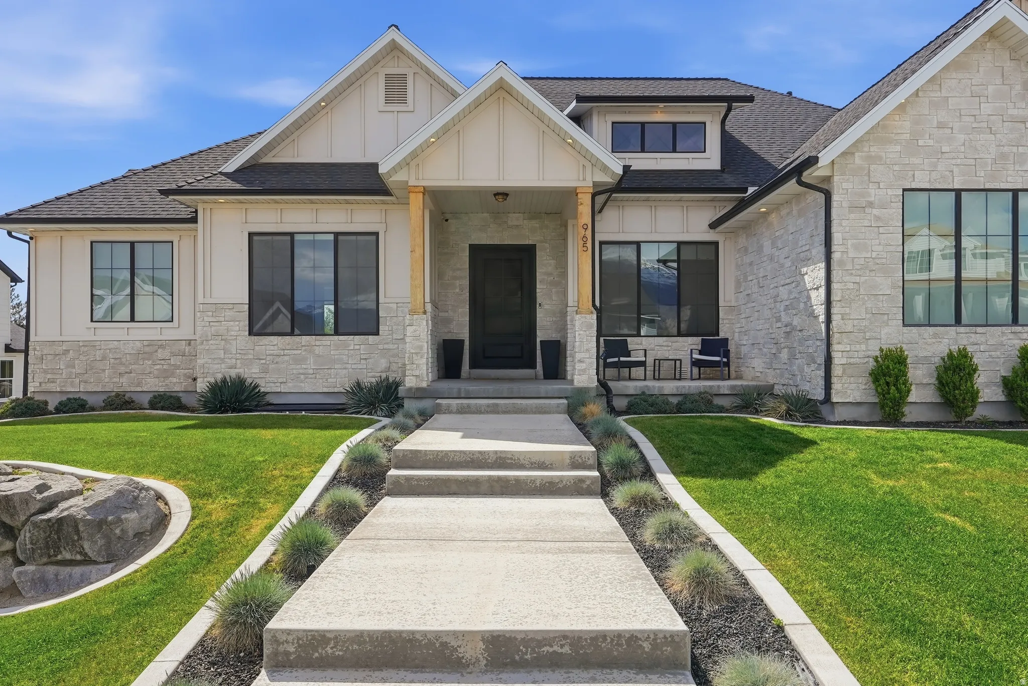 Modern farmhouse exterior featuring light-toned stone and vertical white siding