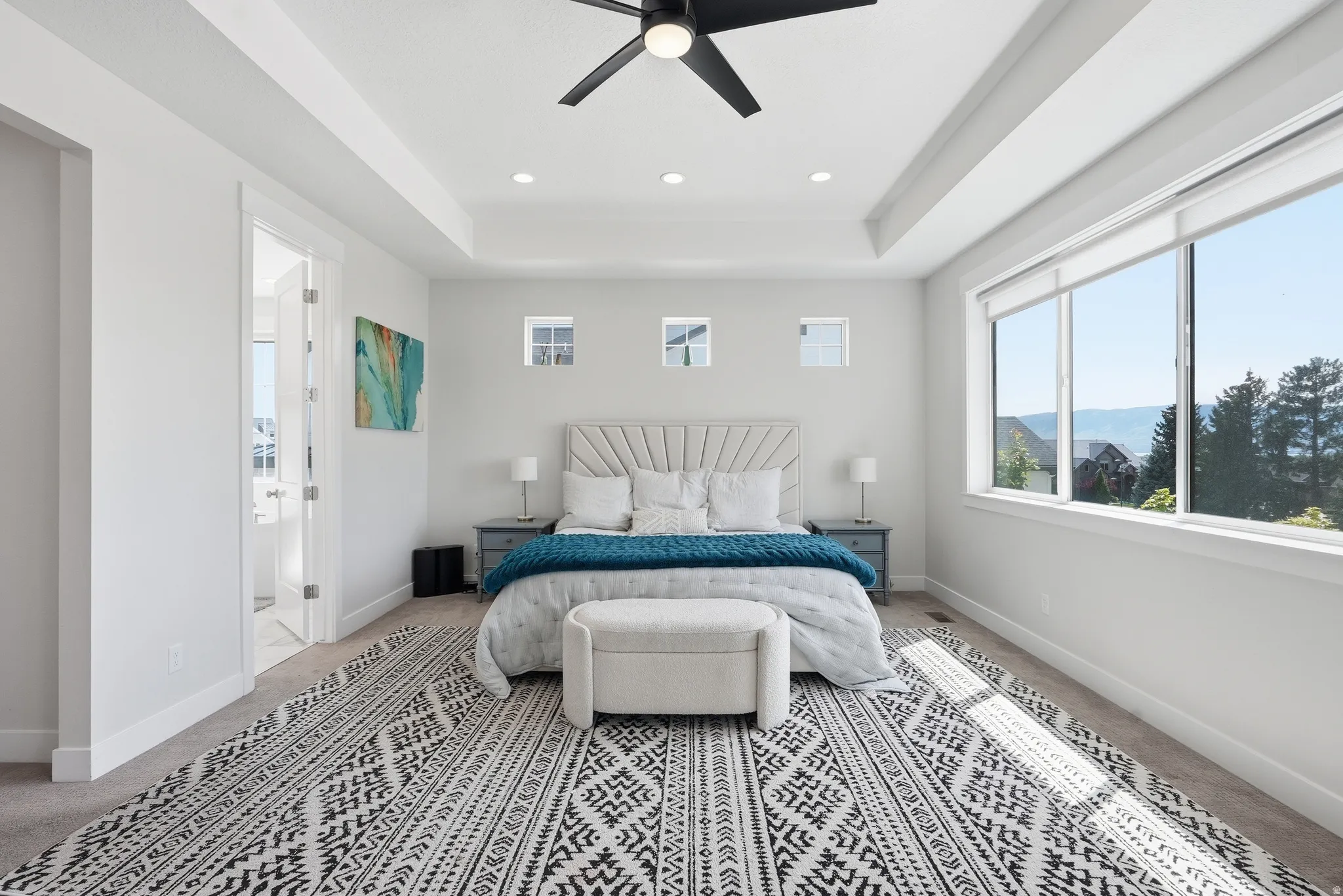 Spacious interior featuring a tray ceiling, recessed lighting, and a contemporary ceiling fan