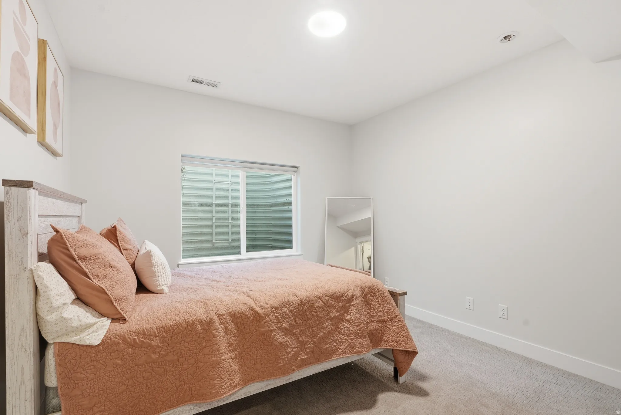 Bedroom featuring light gray walls, plush carpeting, a sliding window, and a ceiling-mounted light fixture