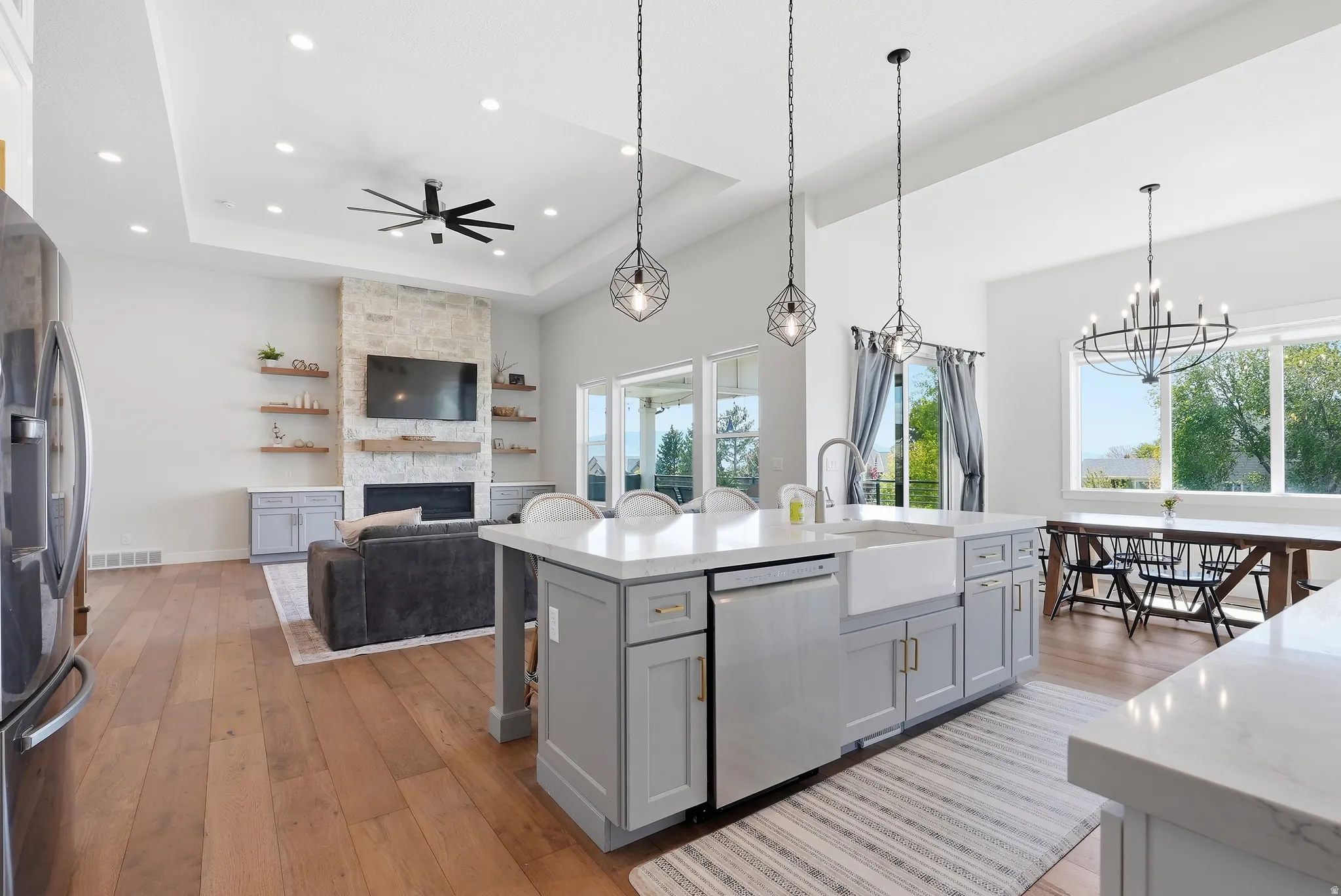Expansive kitchen island featuring a farmhouse sink, light gray cabinetry, and white countertops
