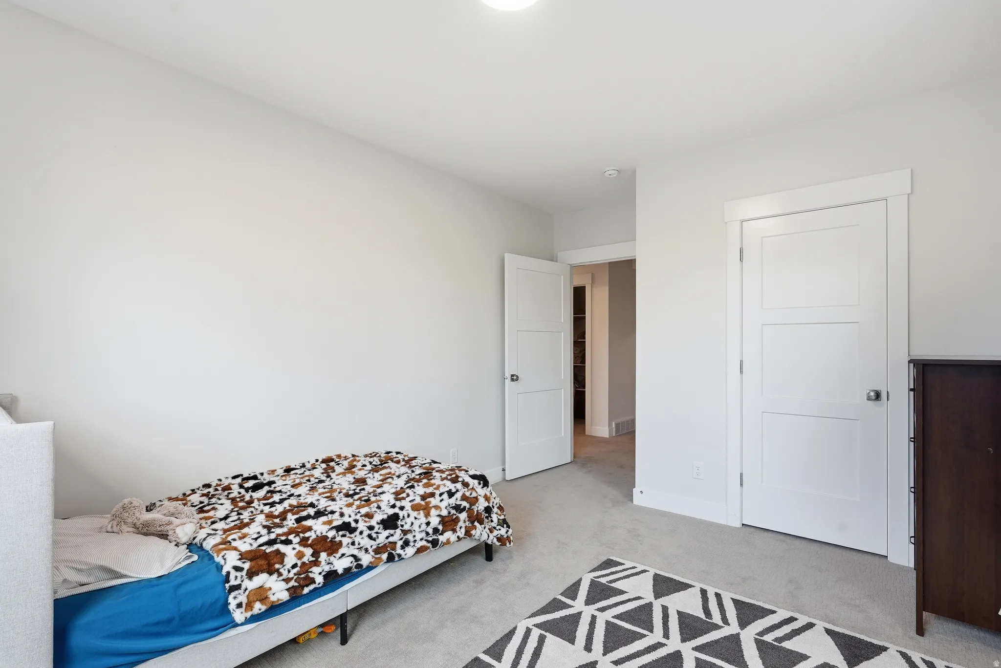 Room featuring light gray walls, gray carpeting, and white trim