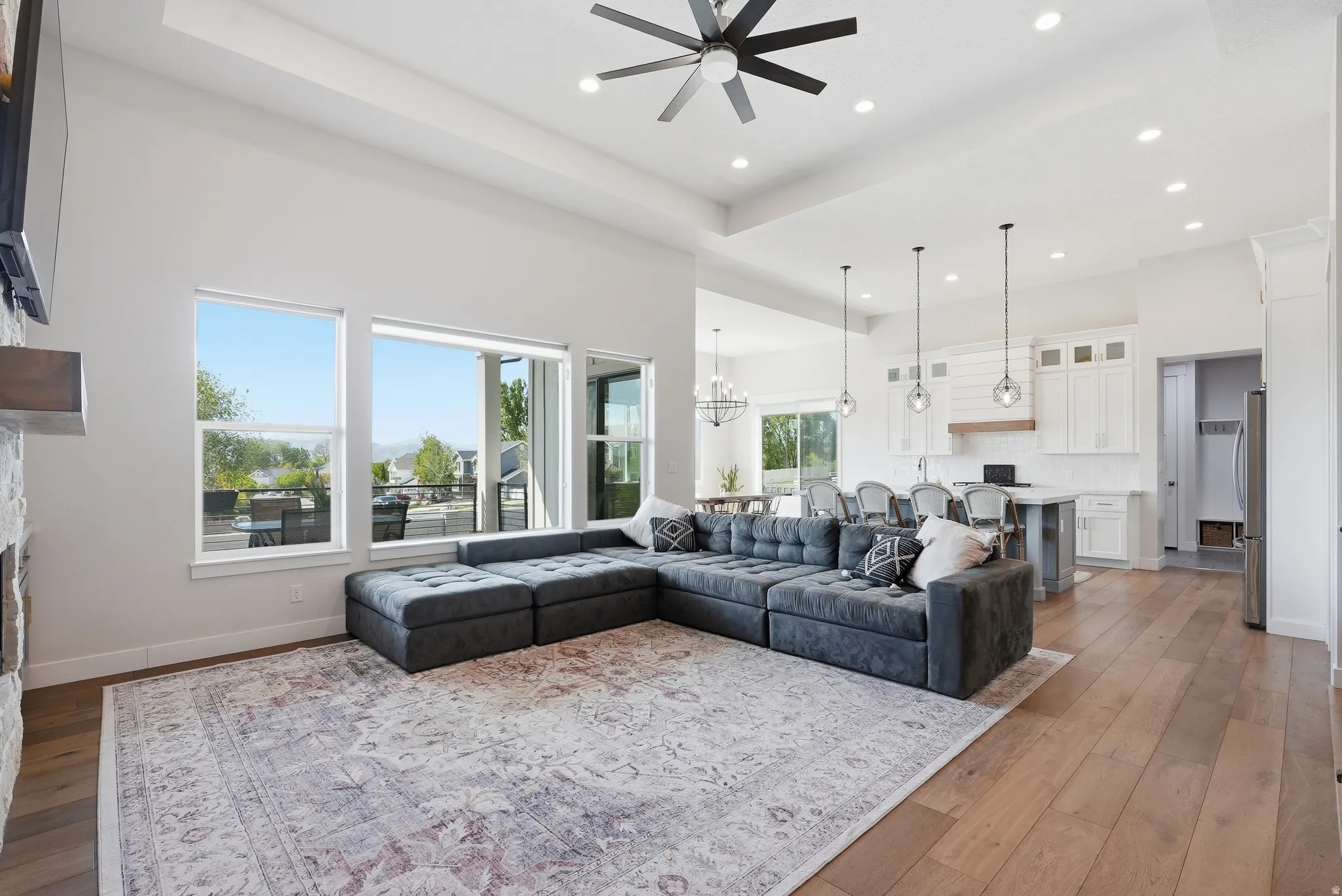 Open-concept living area with high ceilings, recessed lighting, and wood-finish flooring