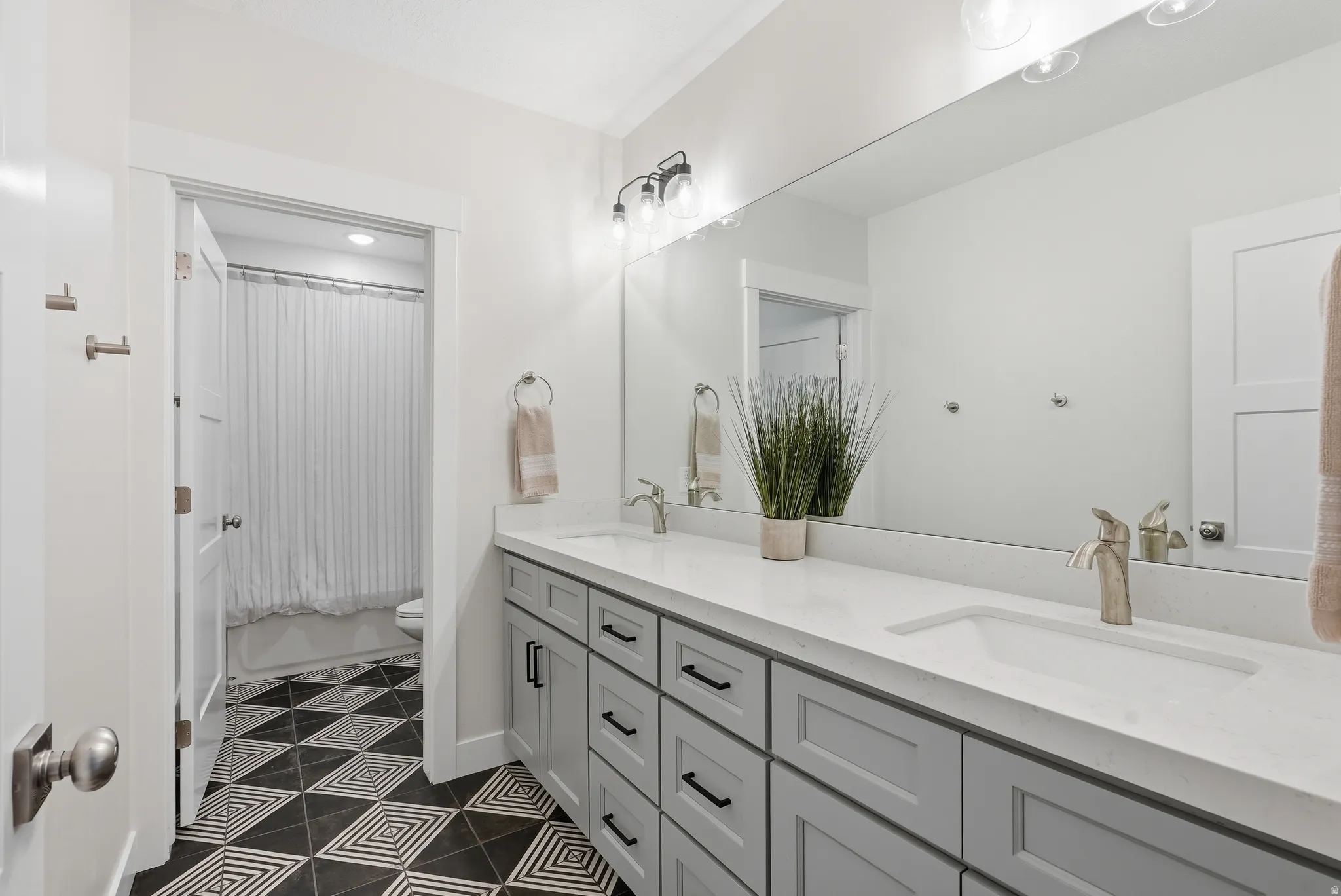 Dual-sink vanity with light gray cabinetry and brushed nickel hardware