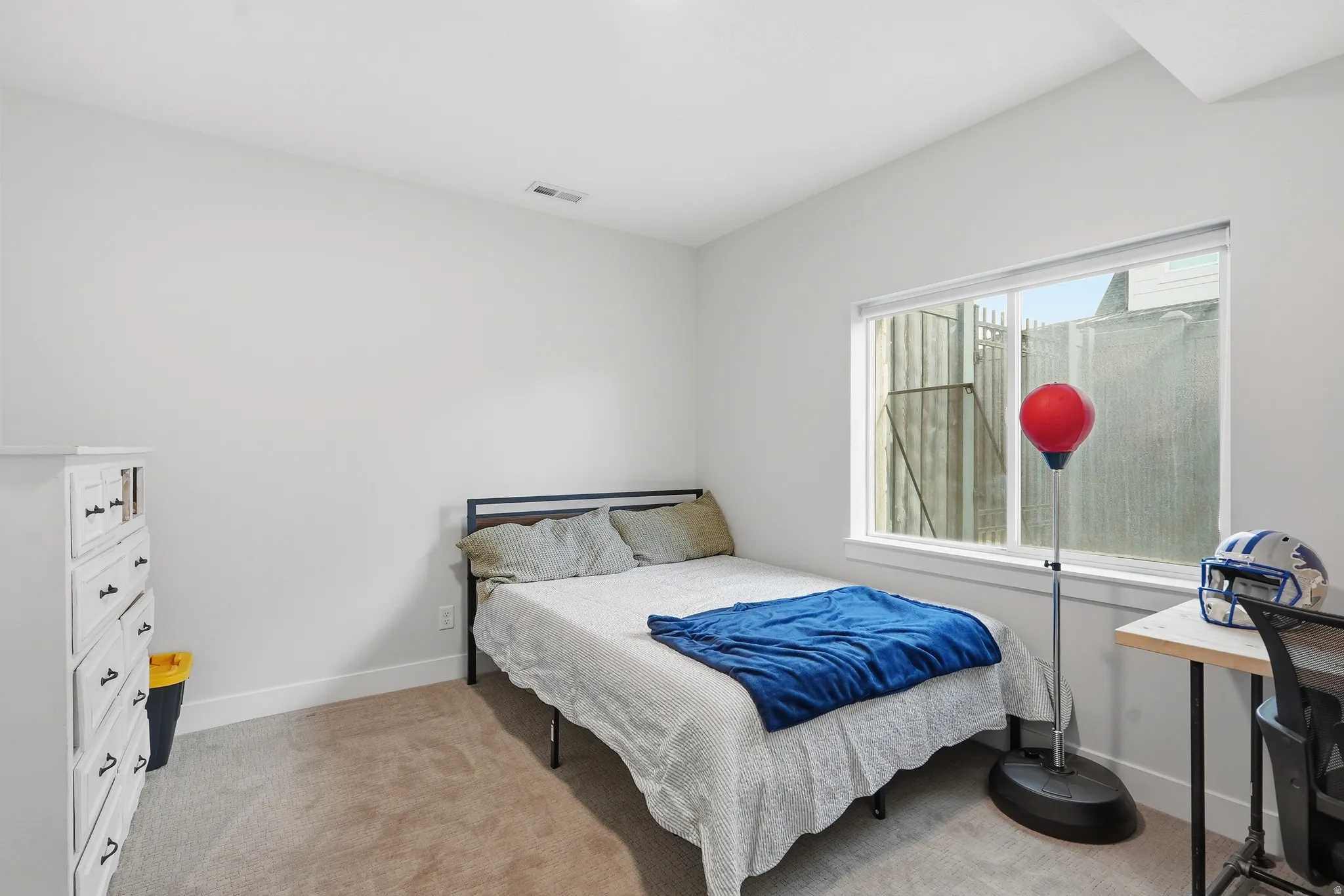 Carpeted room featuring a large window, white trim, and light-toned walls