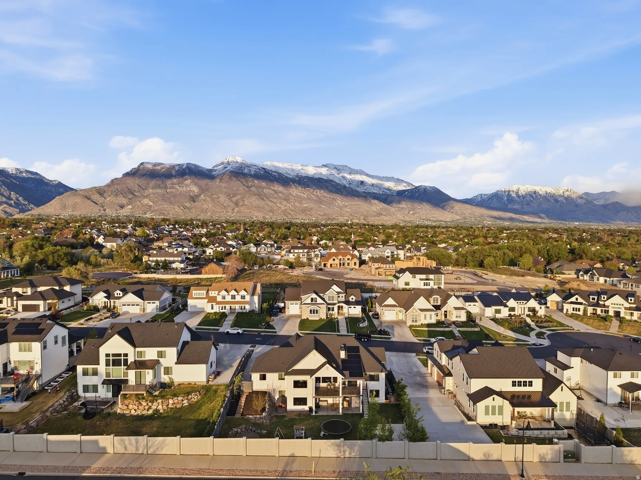 Residential neighborhood with diverse home styles, paved streets, and a mountain backdrop
