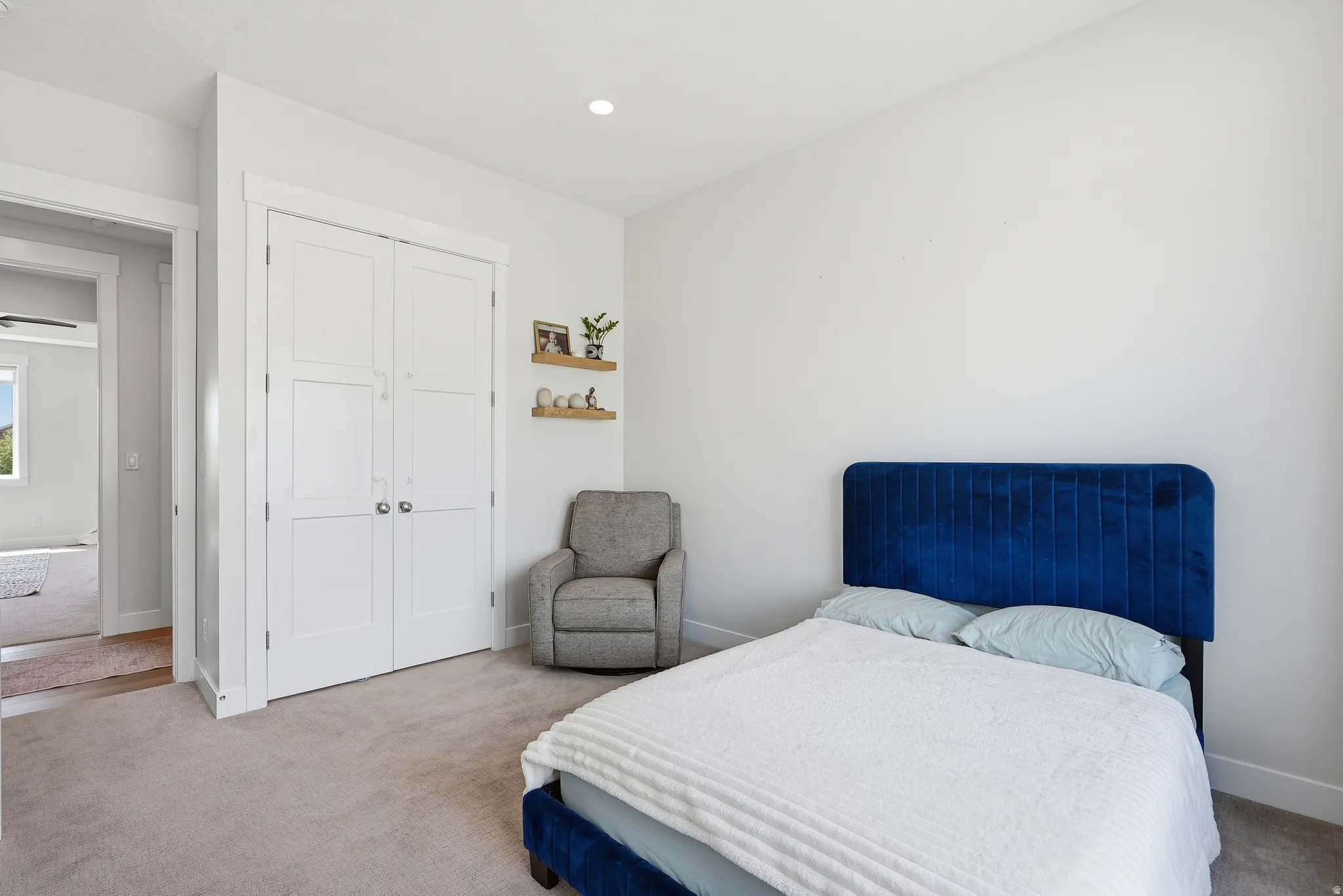 Carpeted room featuring white walls, a built-in closet with paneled bifold doors, recessed lighting, and white trim work