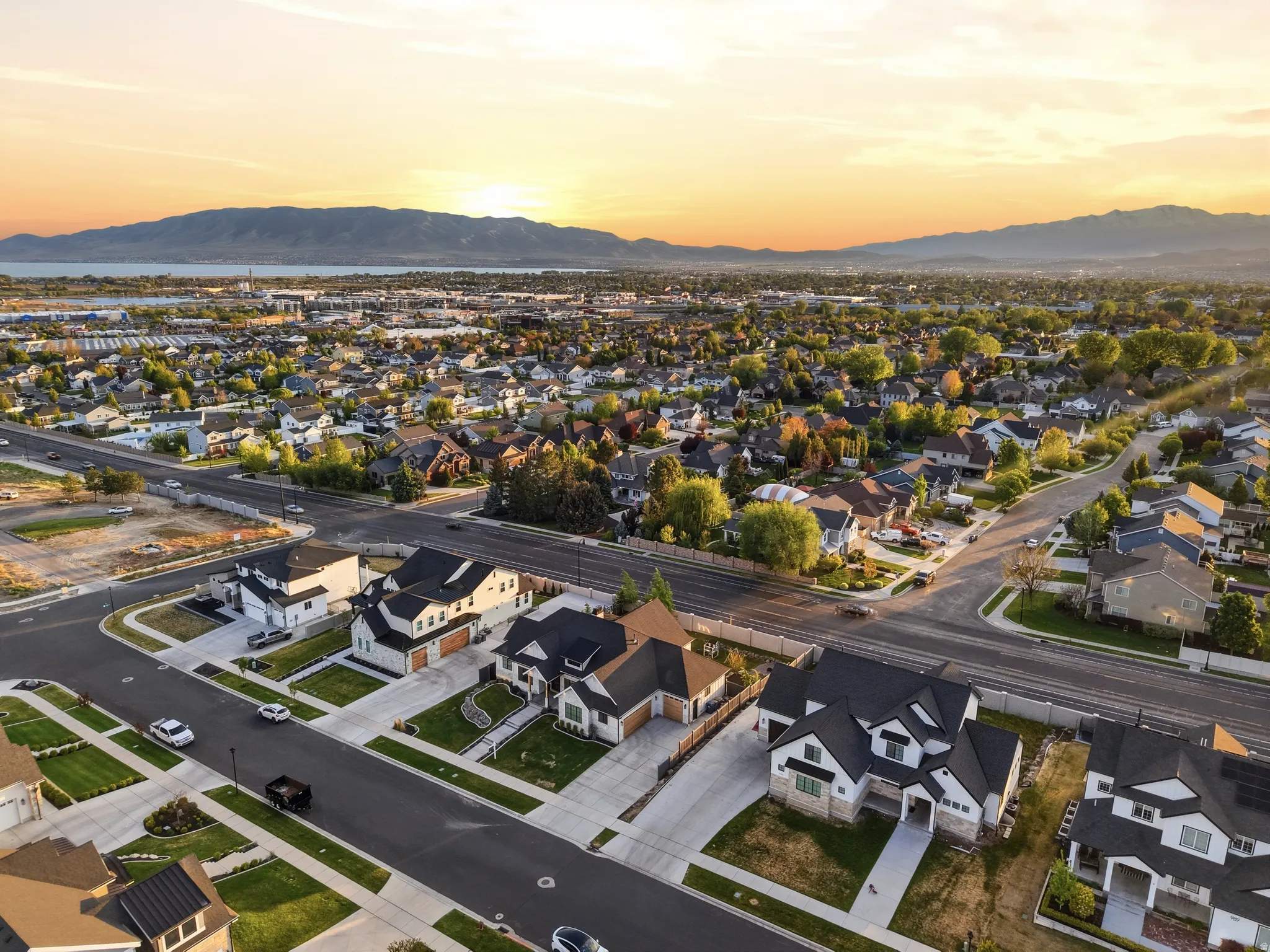 Aerial perspective showcasing a residential neighborhood with a distant lake and mountain range