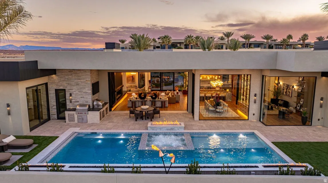Expansive outdoor patio featuring a swimming pool, integrated spa, and fire feature
