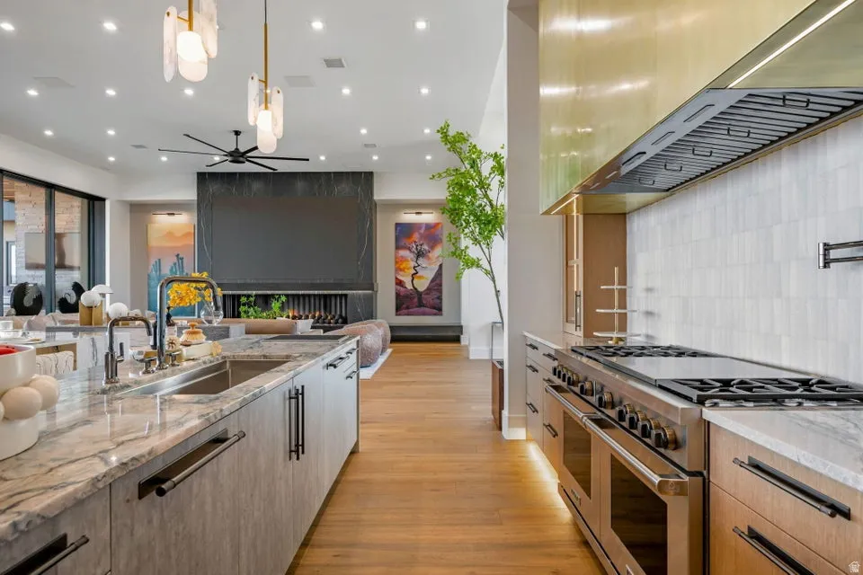 Gourmet kitchen featuring a substantial island with an undermount sink and stone countertop